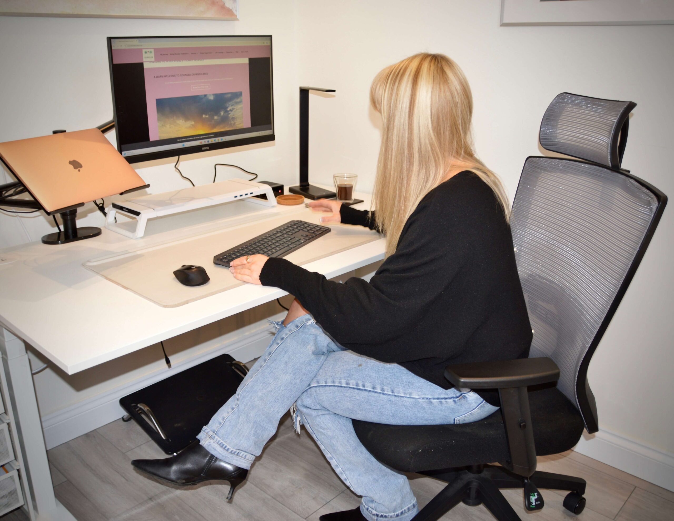 Becky Stone, therapist and business owner, working at her desk on therapy website, admin, and client support tasks.