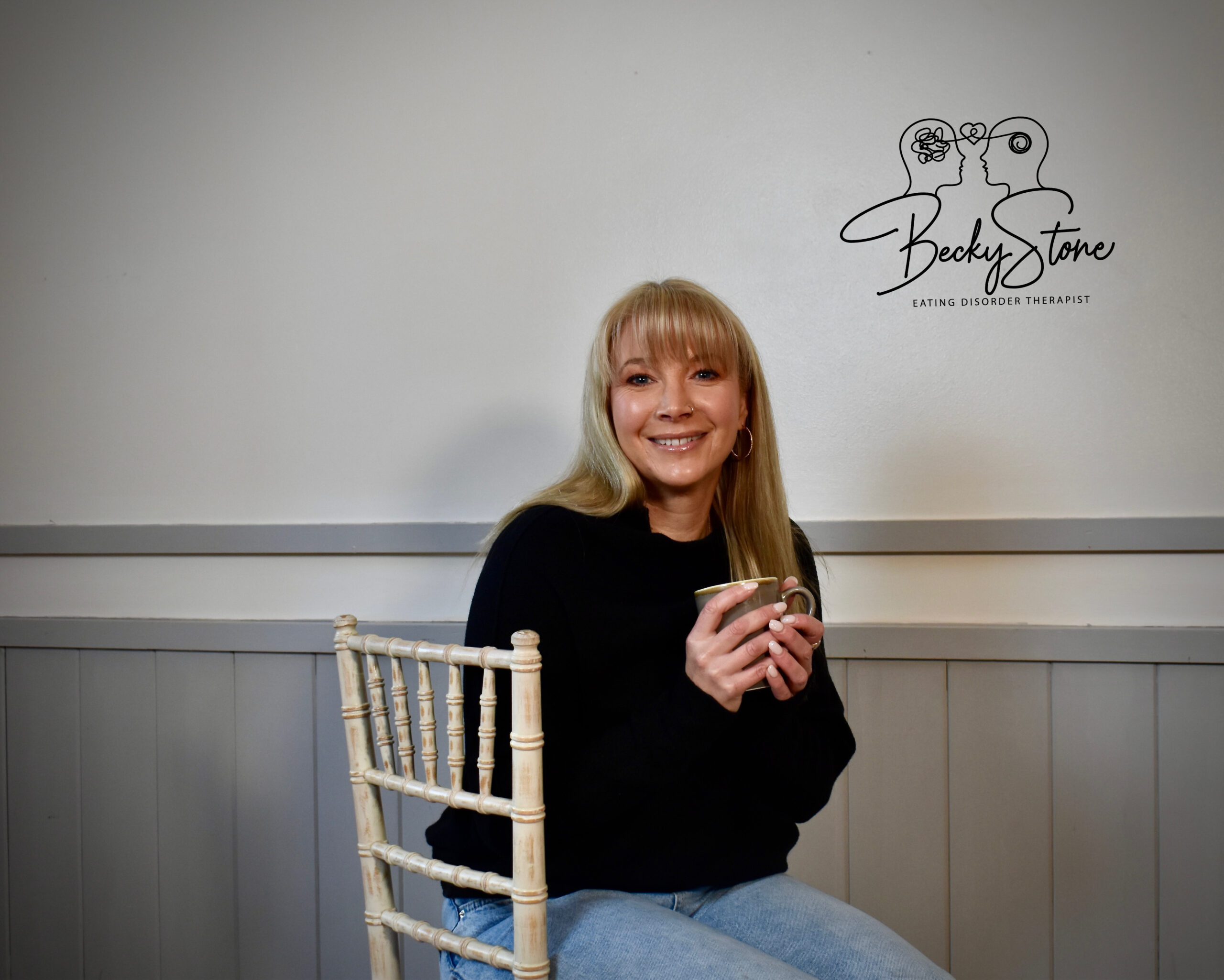 n this photo, Becky Stone sits with a warm smile and a cup in hand—offering a moment of stillness in the often-chaotic journey of bulimia recovery. As an experienced eating disorder therapist, Becky specialises in helping neurodivergent adults and teenagers who feel overwhelmed by shame, binge-purge cycles, and disconnection. Her practice is trauma-informed, ADHD-aware, and completely free from diet culture or judgment.  This image reflects her grounded, compassionate presence, which creates a safe space for clients navigating eating disorders, emotional regulation challenges, and sensory food issues. Becky’s approach blends lived experience, professional insight, and a deep understanding of how neurodivergence and disordered eating intersect. Becky Stone, eating disorder counsellor, holding a cup and offering neurodivergent-friendly support for bulimia recovery and emotional regulation.