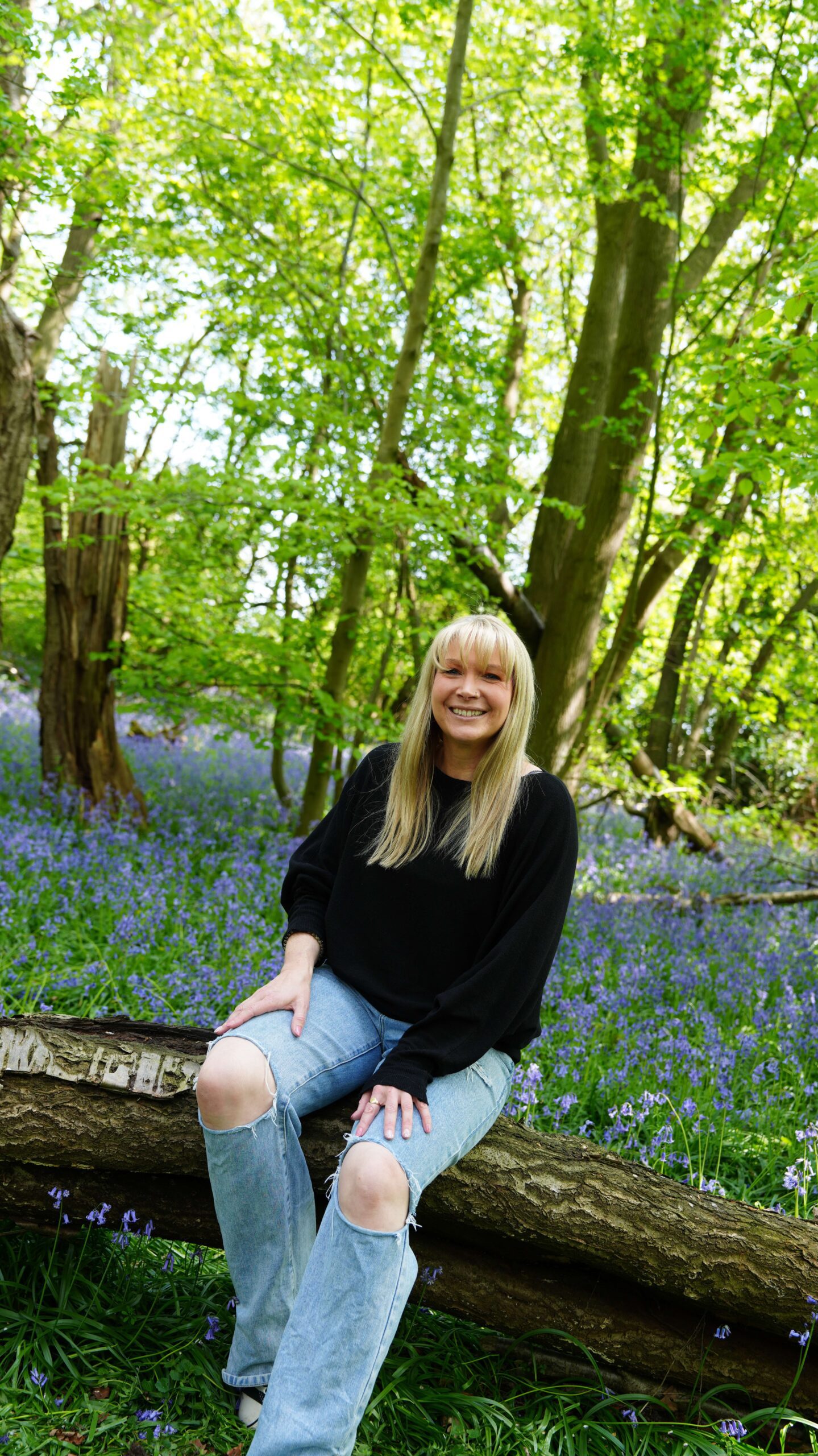 Becky Stone – Walk and Talk Supervision in Canterbury Therapist Becky Stone sitting outdoors in a forest area offering walk and talk supervision