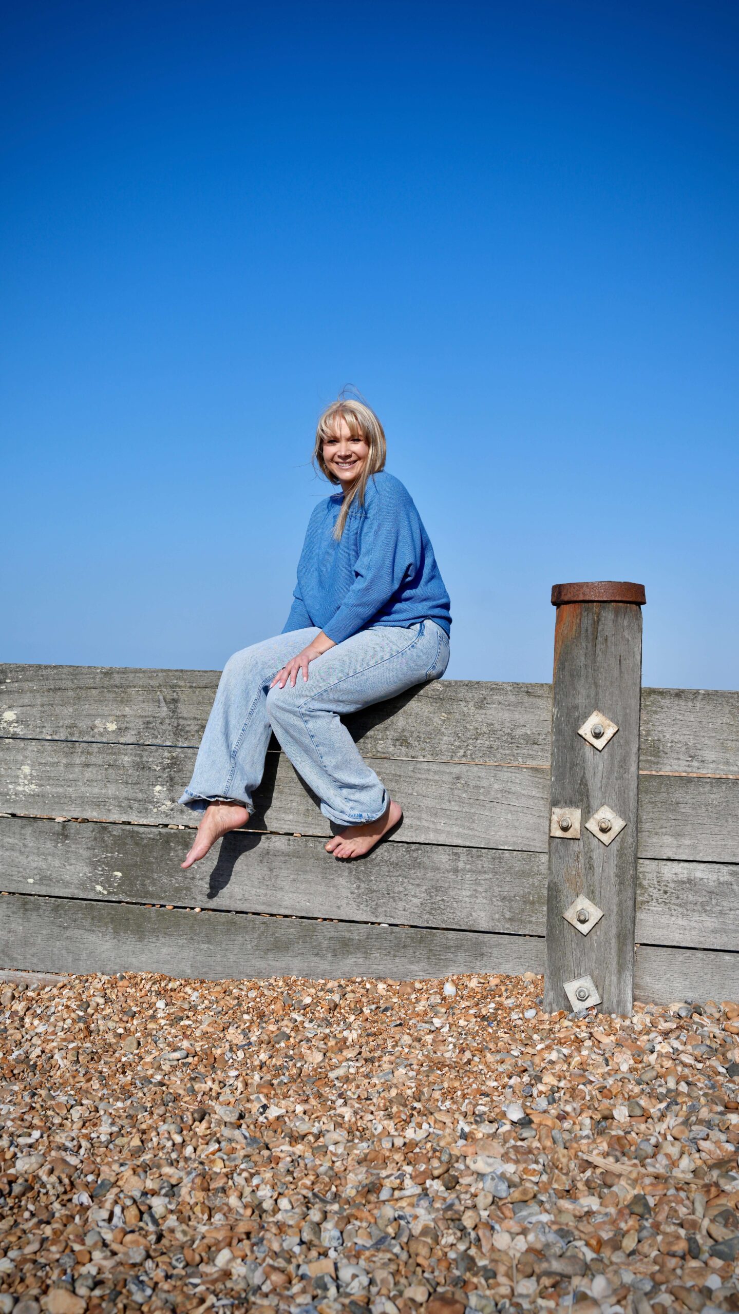 Becky Stone sitting confidently outdoors, trauma-informed eating disorder therapist based in Canterbury