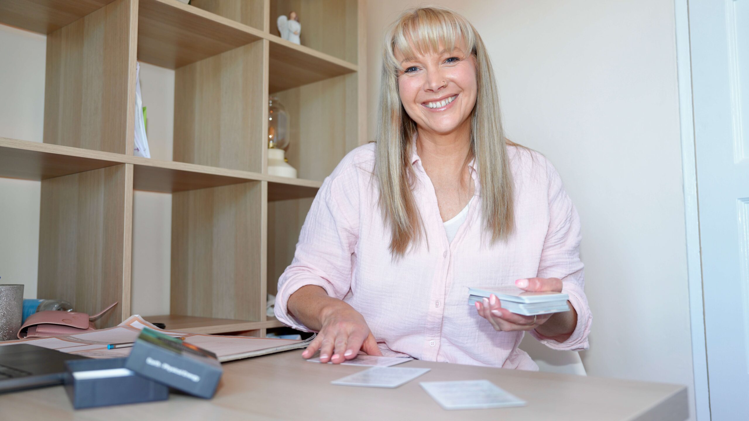 Becky Stone Therapist in Office – Eating Disorder Recovery Support Becky Stone, eating disorder therapist, smiling in her therapy room while writing client notes – representing safe, compassionate support for ED recovery.