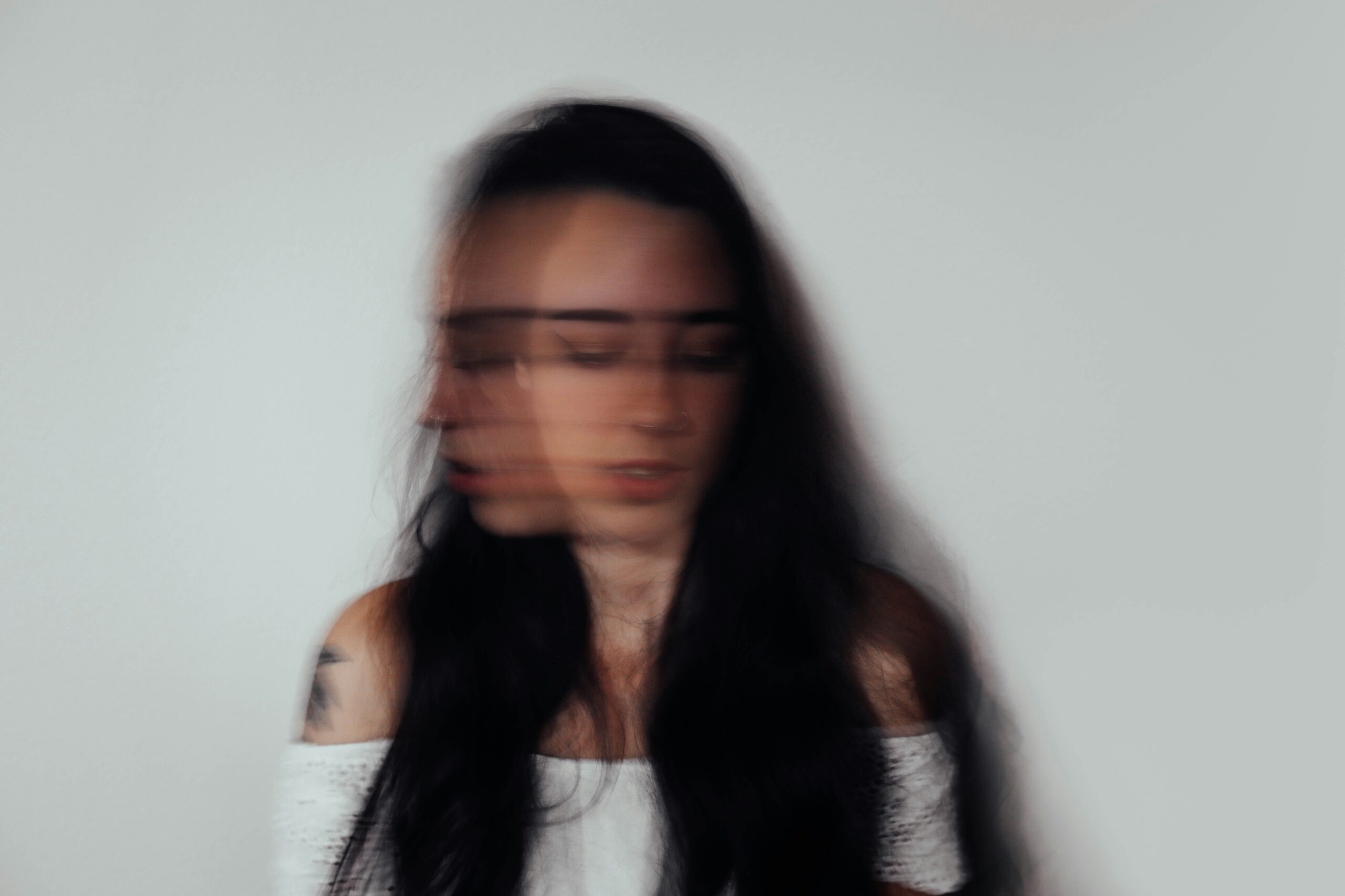 Blurred Woman in Distress – Invisible Eating Disorder and Shame Blurred photo of a distressed woman shaking her head – symbolising the internal chaos, self-doubt, and hidden struggle of eating disorders.