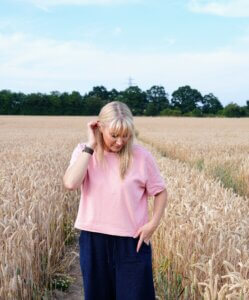 Becky Stone walking through a summer meadow, reflecting on neurodivergent body image and eating disorder recovery.