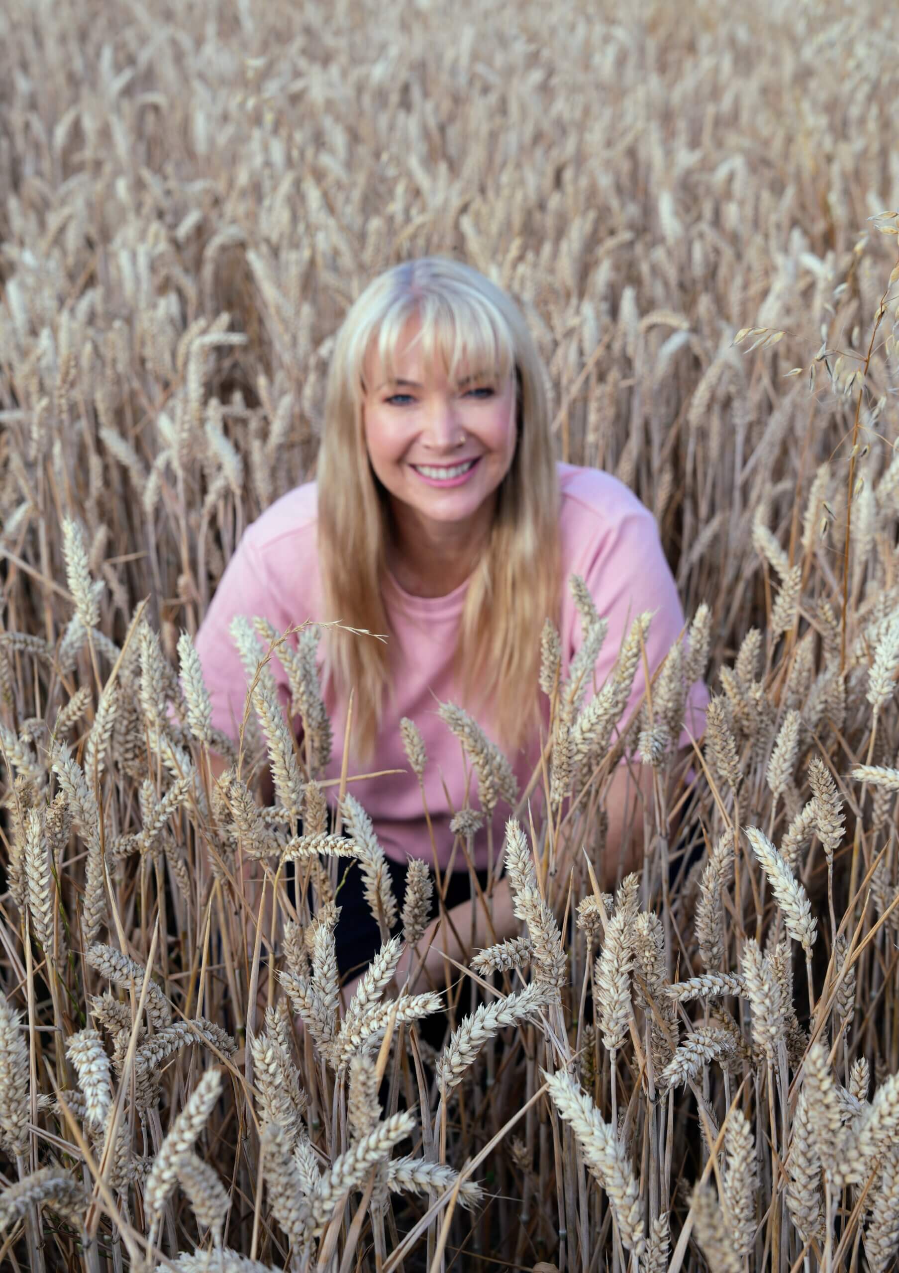 Becky Stone, specialist eating disorder counsellor, smiling in a wheat field, offering online eating disorder therapy across the UK.