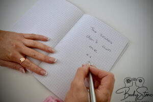 Becky Stone writing reflections in a notebook during an online counselling exercise